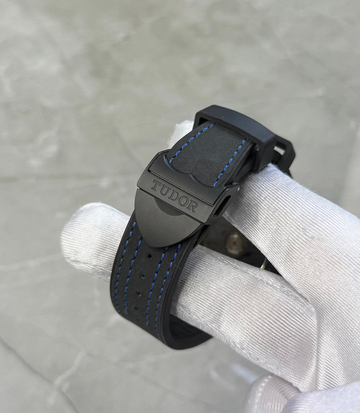 Tudor Black Bay Ceramic close-up of the dark branded buckle and blue-stitched black strap.