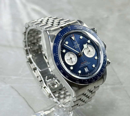 Tudor Black Bay Chronograph Blue angled view on a clear stand showing blue dial and the bracelet loop.