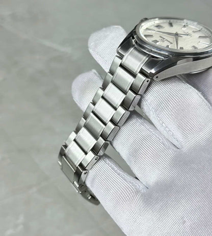 Grand Seiko White Birch bracelet close-up showing broad centre links and the angular case side.