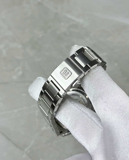 Grand Seiko White Birch close-up of the GS-logo clasp and bracelet in a white glove.