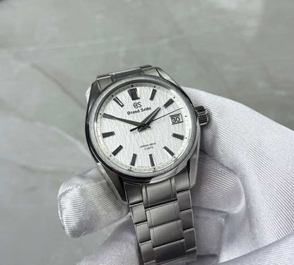 Grand Seiko White Birch held in a white glove showing the white textured dial and broad hour markers.