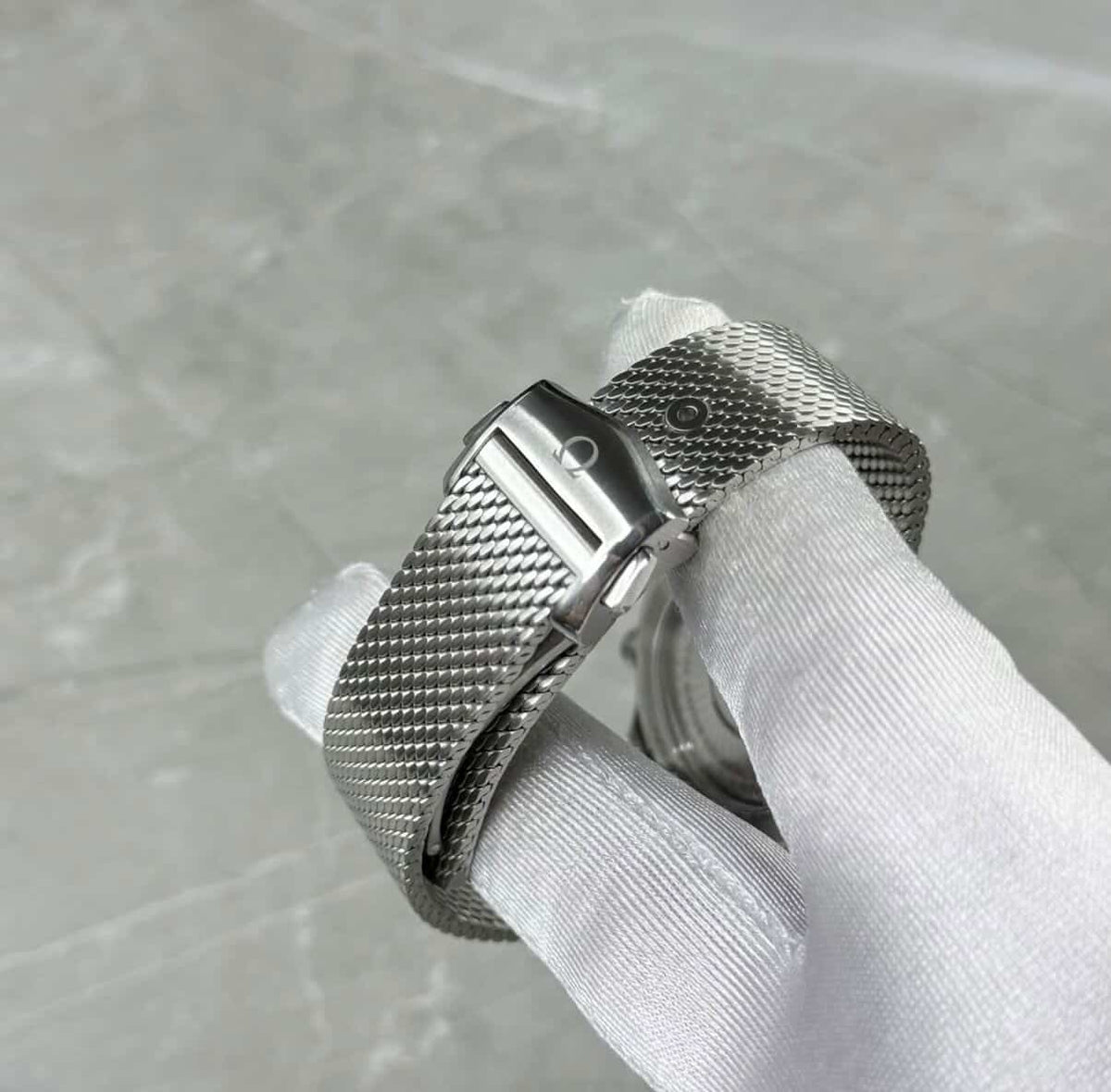 Omega Seamaster Diver 300M clasp-side close-up showing mesh texture and adjustment holes.