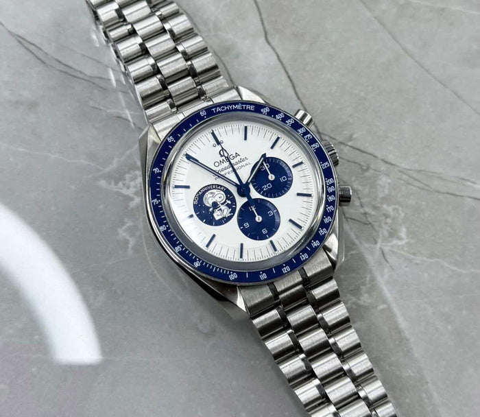 Omega Speedmaster Snoopy lying flat with pale dial, blue subdials, blue tachymeter bezel and bracelet.