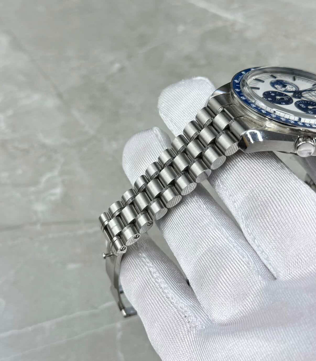 Omega Speedmaster Snoopy bracelet close-up showing narrow links and the crown and pushers.