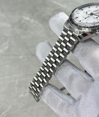 Omega Speedmaster angled bracelet view in a white glove with white dial and black bezel visible.