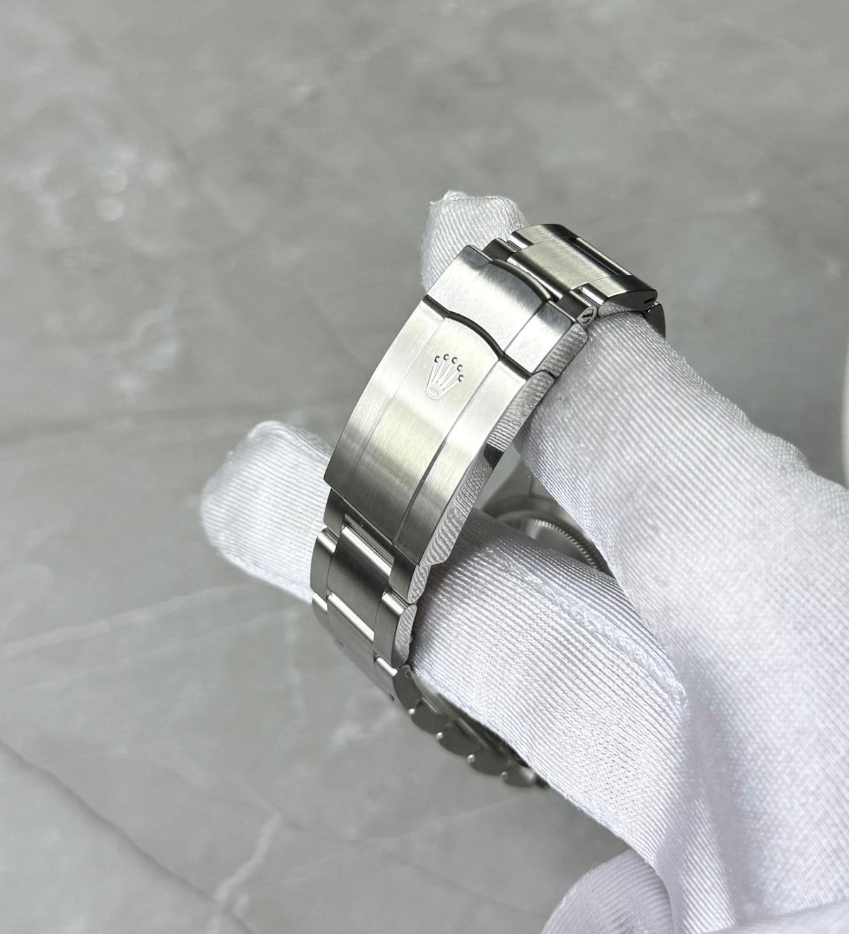 Rolex Oyster Perpetual 36 close-up of the folding clasp and bracelet held in a white glove.