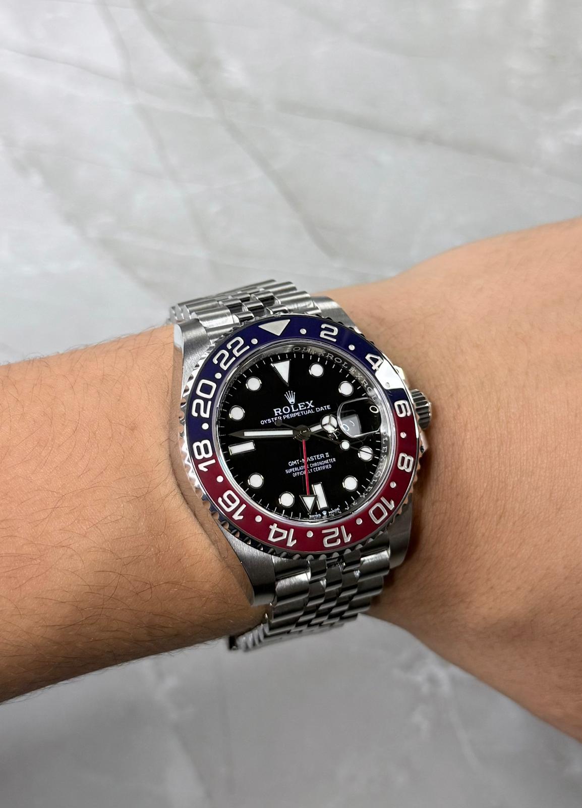 Rolex GMT-Master II Pepsi on wrist with red-and-blue bezel and five-link bracelet.