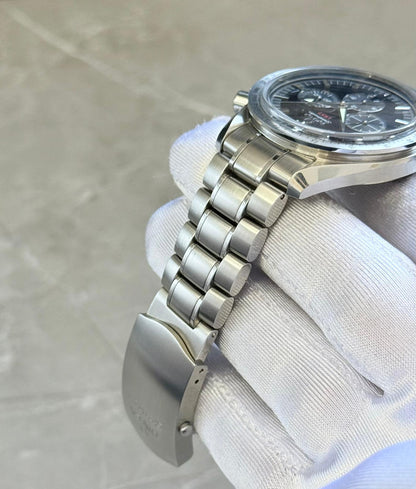 Omega Speedmaster Broad Arrow angled bracelet view showing rounded links and open folding clasp beneath the case.