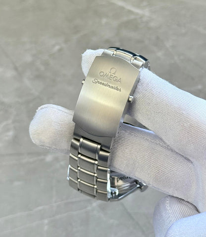 Omega Speedmaster Broad Arrow close-up of the Omega Speedmaster-branded folding clasp in a white glove.