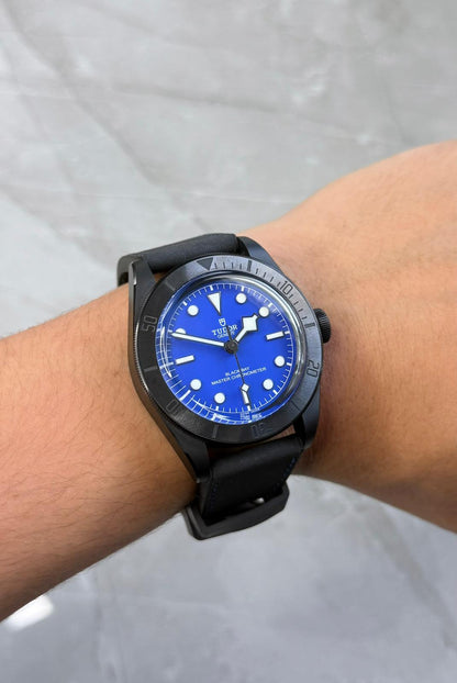 Tudor Black Bay Ceramic on wrist with blue dial and black strap.